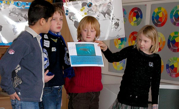 Vier Klima Kids halten ein Blatt Papier hoch. Foto: Welthaus Bielefeld